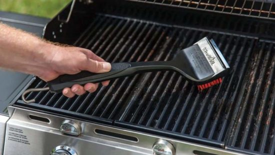 Man cleaning grilling grates with a grilling brush