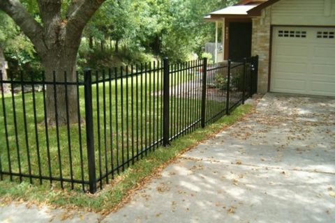 Ornamental iron fence in an L shape on a front yard of an Austin property