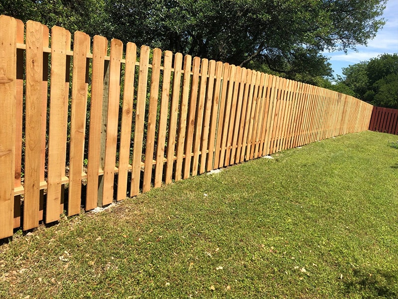 Shadow box fence in the backyard of an Austin property. Shadow box fences have pickets placed with even spacing between them.