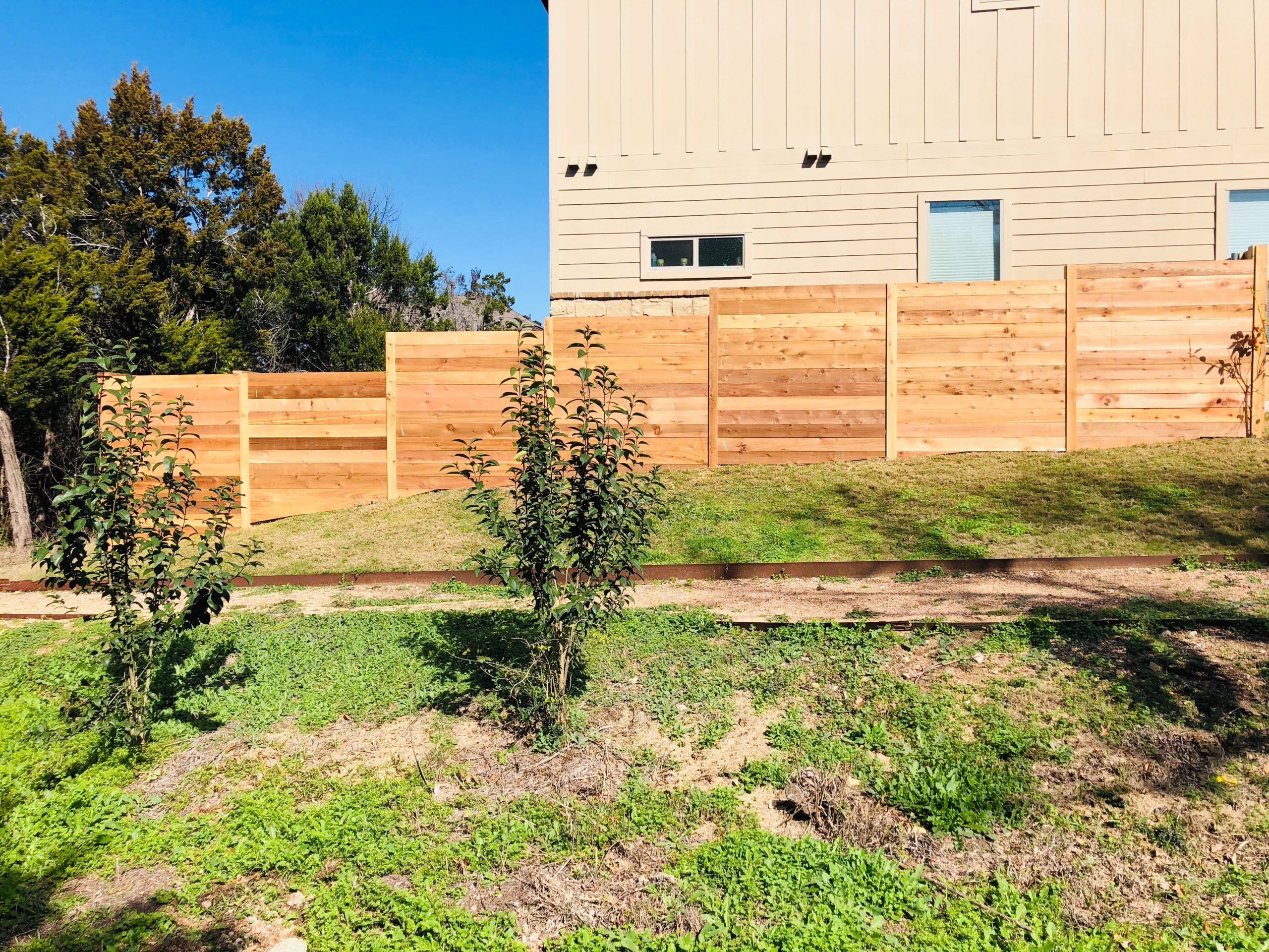 Horizontal wood fence on a sloped backyard in Central Texas