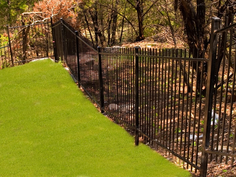 Stepped iron fence on a slope of a backyard in Central Texas