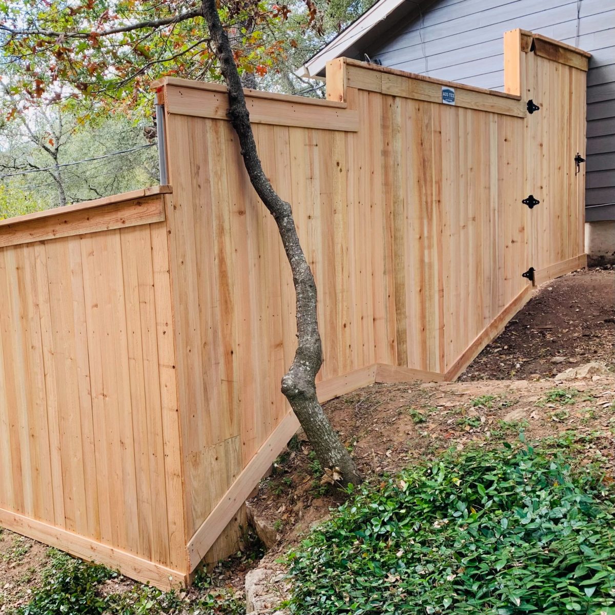 Wood fence with gate on a steep and irregular slope in Central Texas