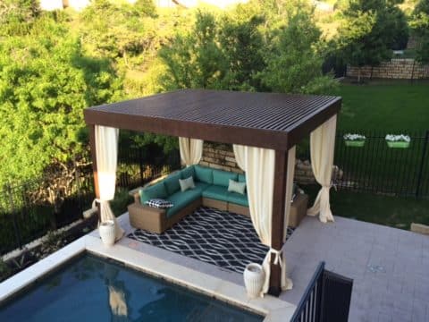 Pergola with outdoor curtains next to a pool