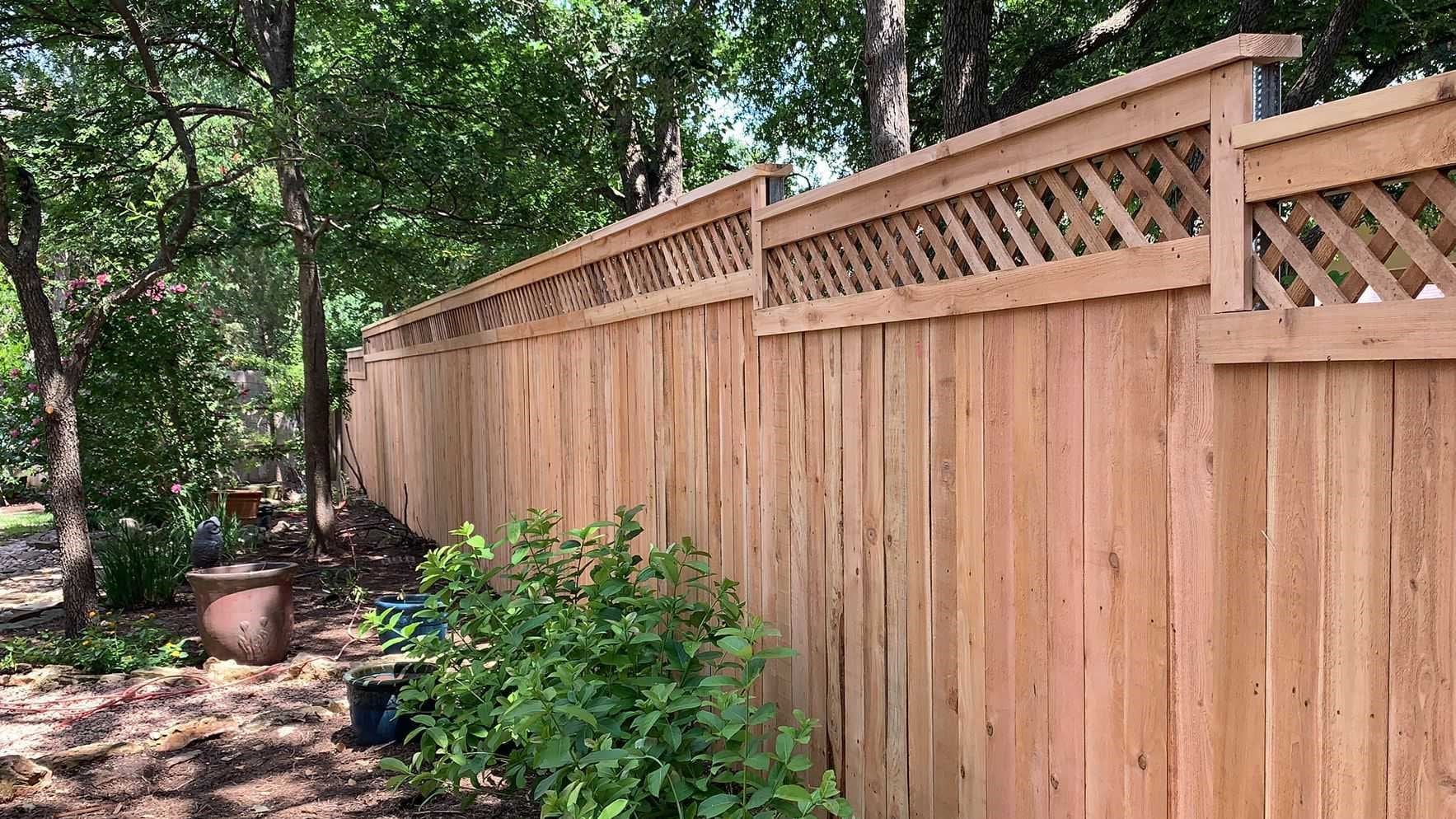Wood lattice fence in a backyard on a slight slope in Central Texas