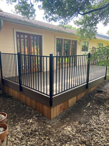 composite deck with iron railing and wood skirting
