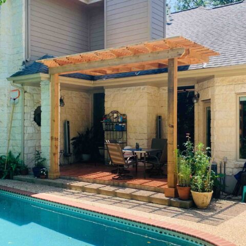 Wooden pergola covering deck by pool