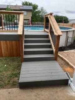 Custom deck built around above ground pool with stairs