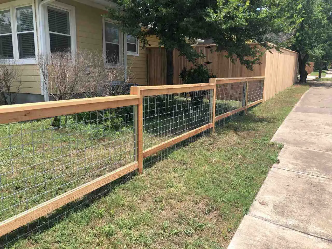 Stepped wired fence with wood frame on a small slope on the backyard of a Central Texas home 