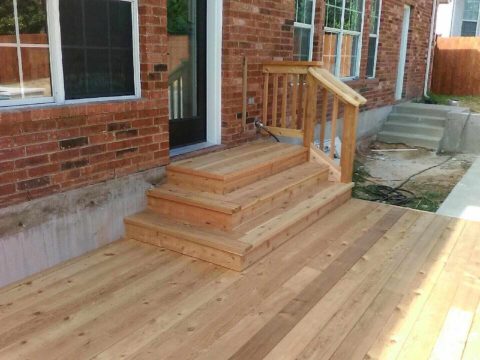 Custom deck with three stairs from back door and small railing