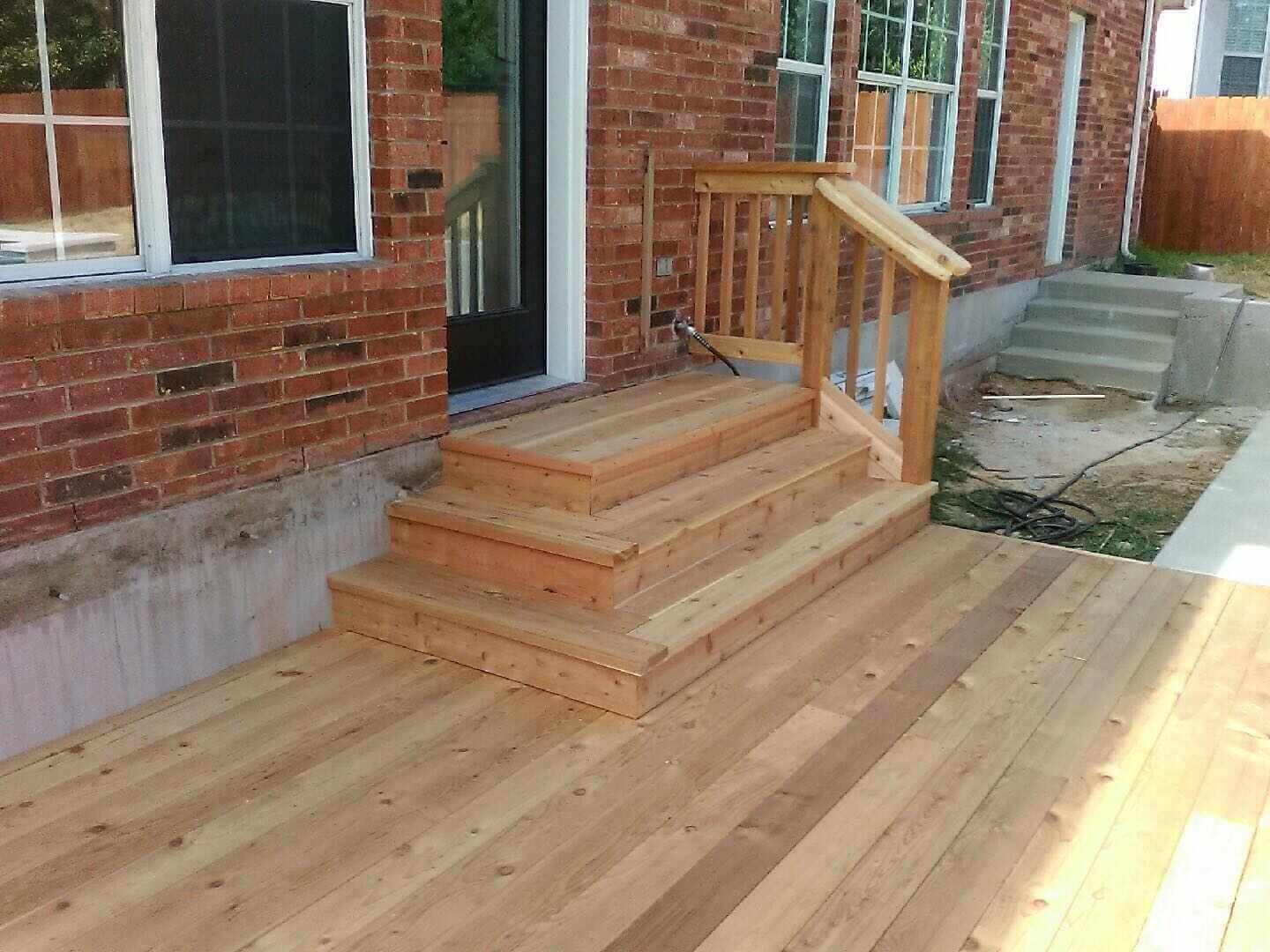 Custom deck with three stairs from back door and small railing