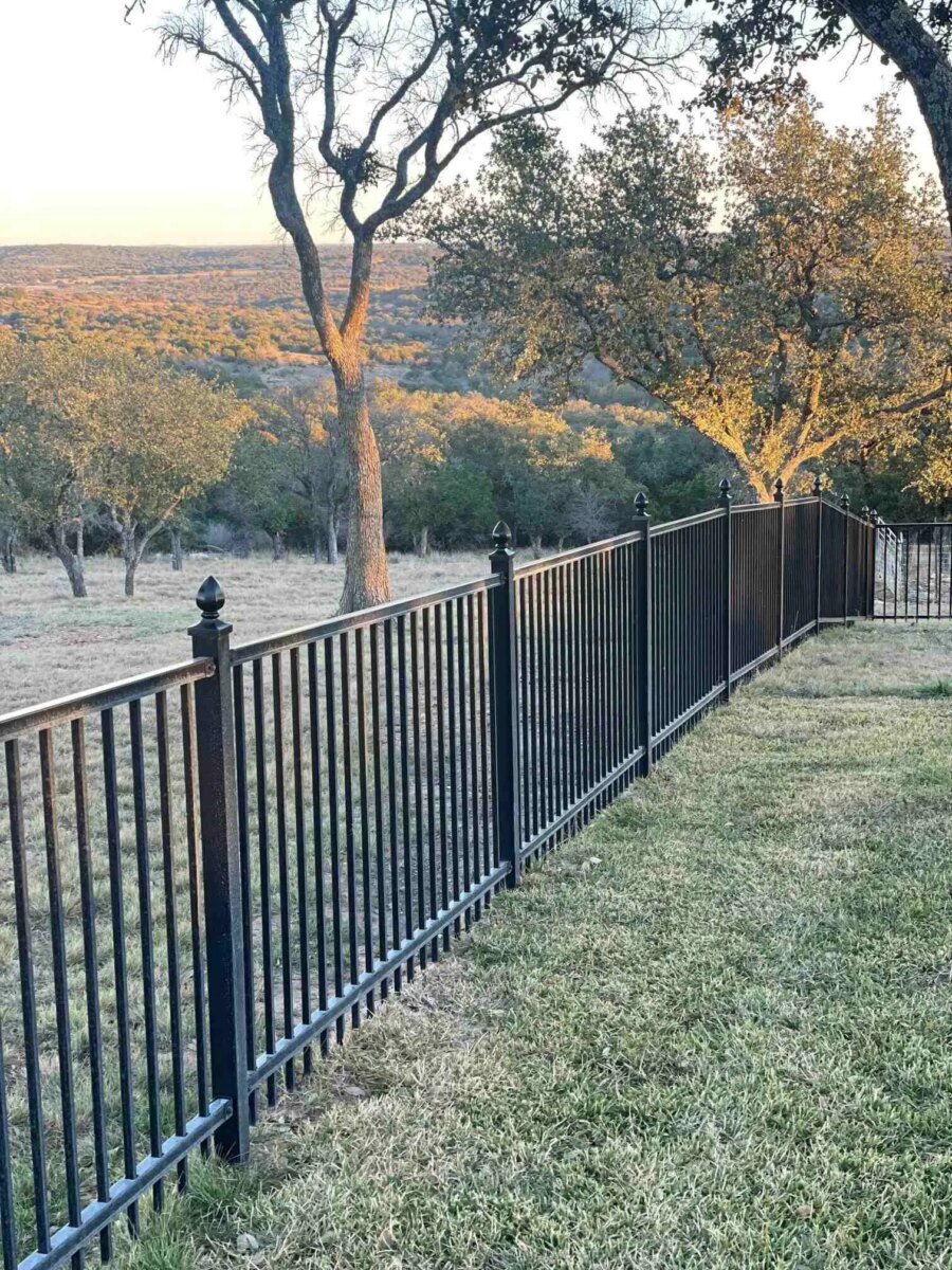 Residential flat top iron fencing with decorative finial on posts