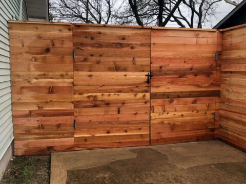 Horizontal wood fence with cap and trim and a two hinge double wide gate