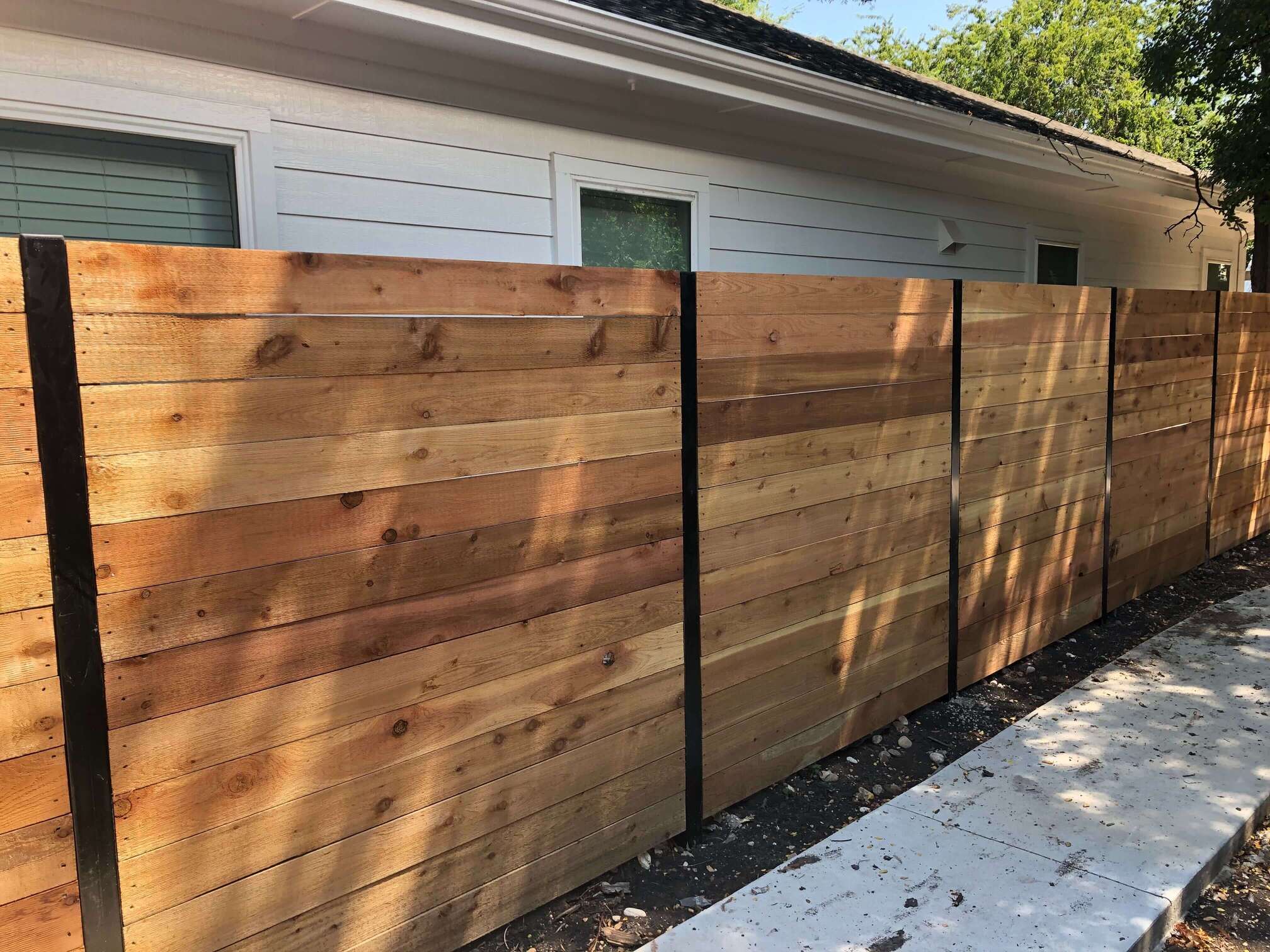 six foot horizontal cedar fence with black exposed posts