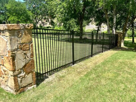 flat top iron fence attached to stone pillar