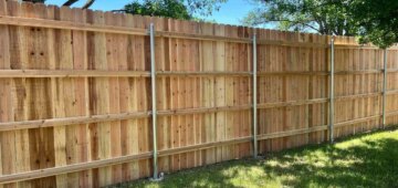 six foot wooden privacy fence with four rails and steel posts