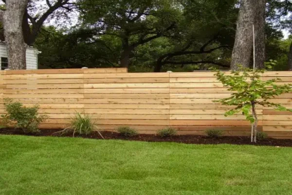 Horizontal wood fence on sloped terrain in Austin