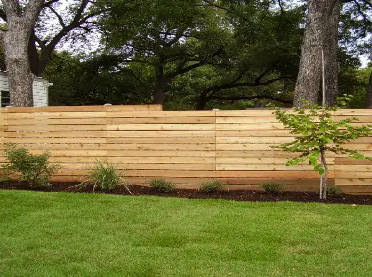 Horizontal wood fence on sloped terrain in Austin