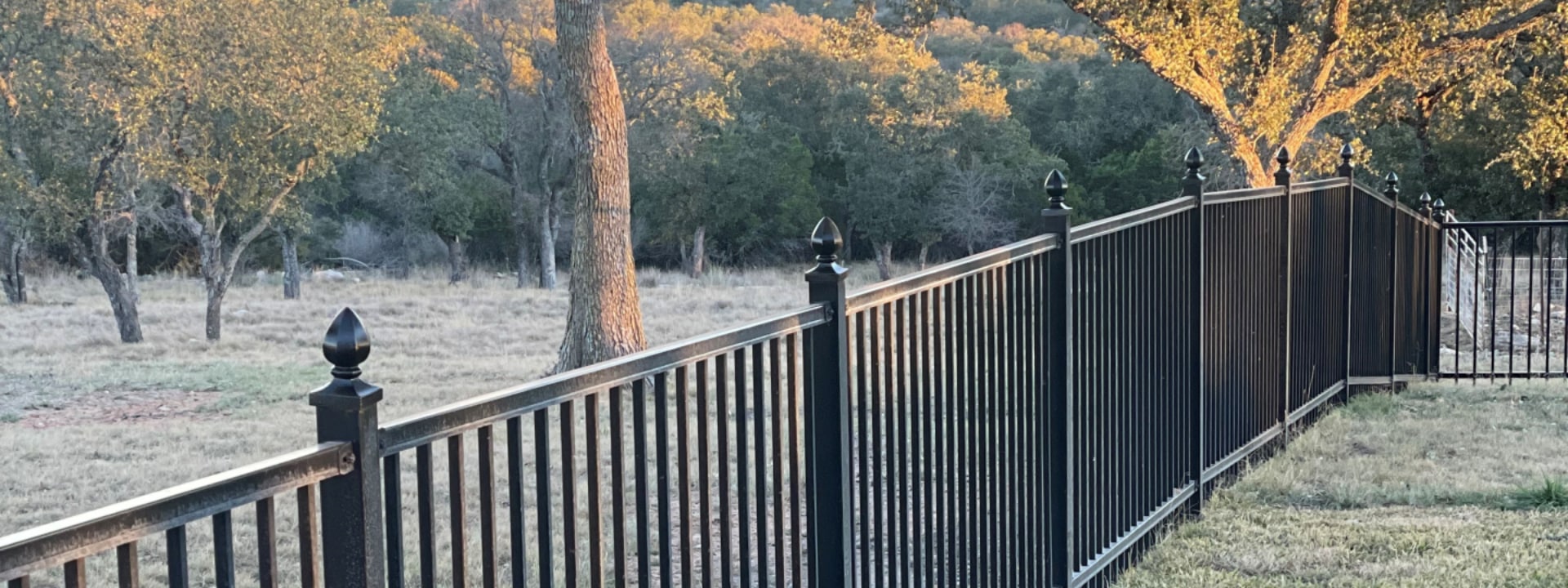 Iron fence with ornamental iron toppers enclosing a big property in Austin, Texas