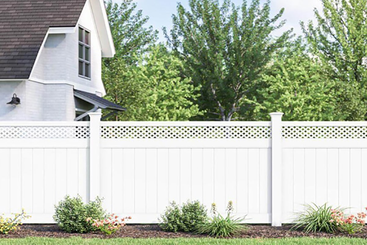 Arrowwood vinyl fence in white, has a lattice on top, enclosing a backyard