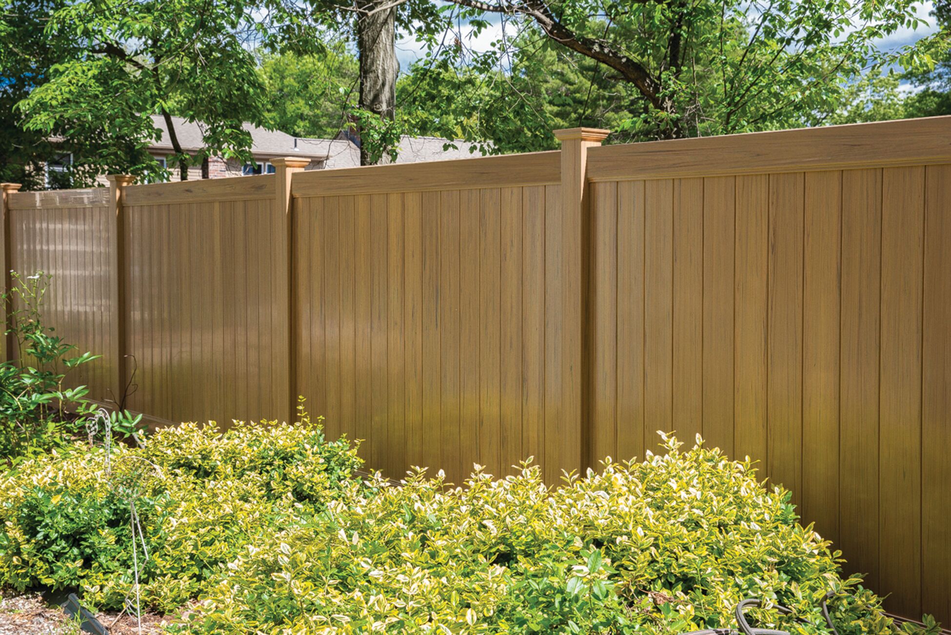 Dogwood vinyl fence in cypress color enclosing a backyard