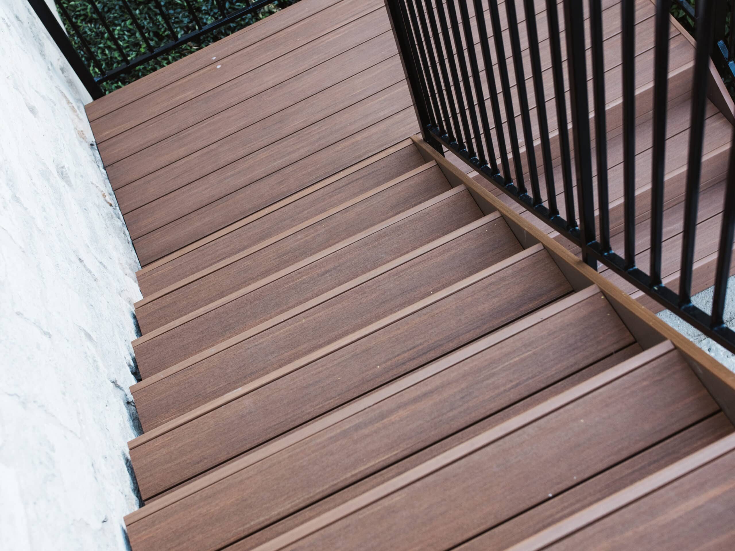 Brown composite deck staircase with iron railing