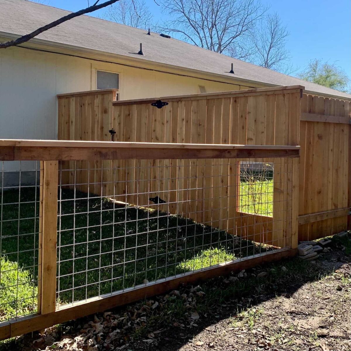 Wood dog fence with doggie window in an Austin property