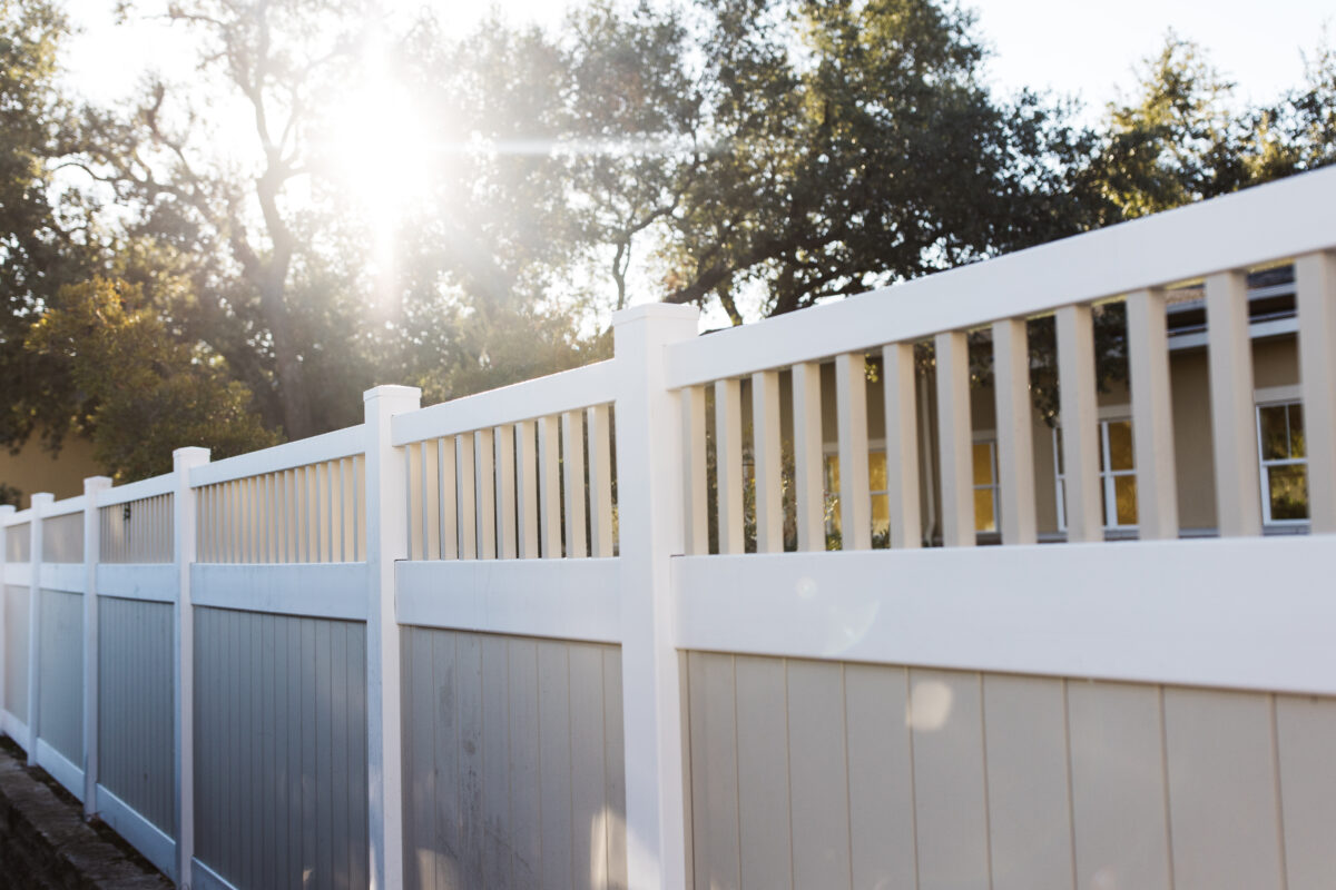 White and sand vinyl fence with pickets on the top