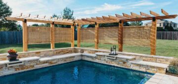 L-shaped wood pergola enclosing a part of a pool with a lattice screen for added privacy